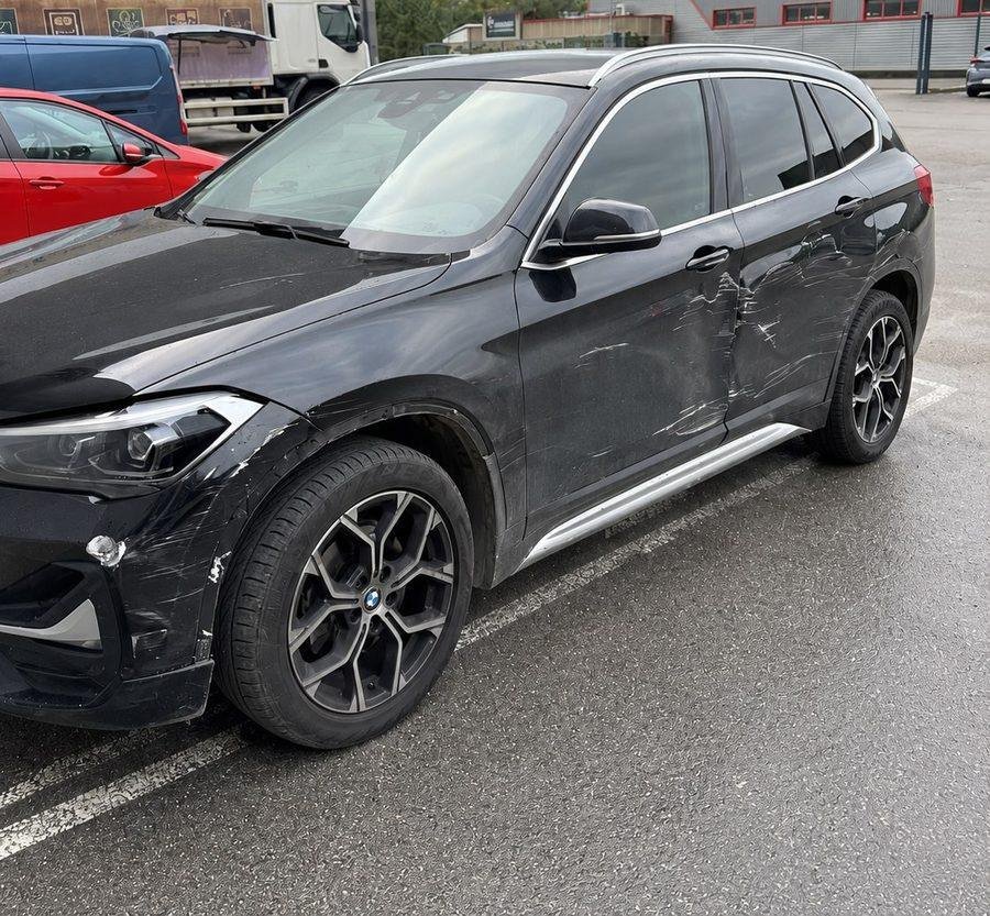 BMW X1 noire rayée et enfoncée sur le côté avant réparation